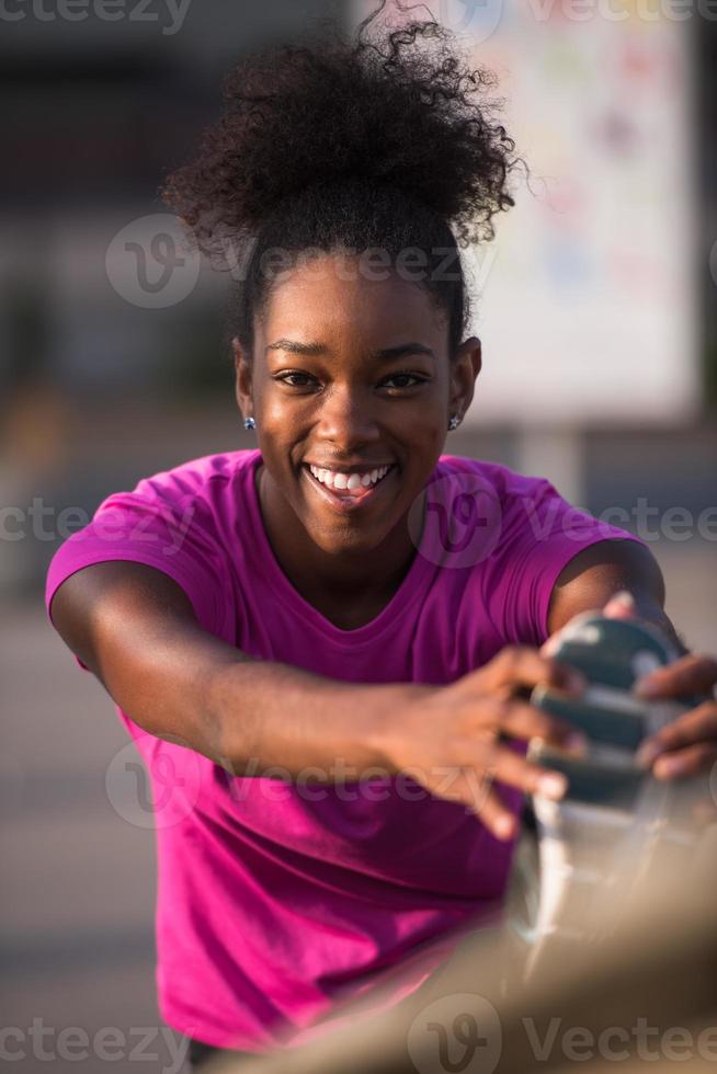 afrikansk amerikan kvinna håller på med uppvärmningen upp och stretching foto
