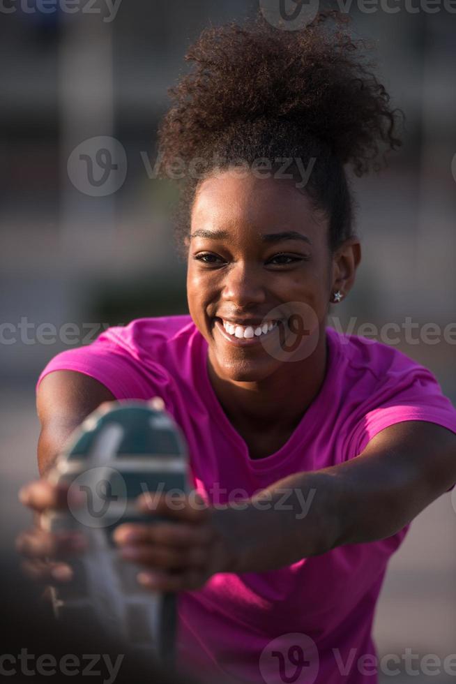 afrikansk amerikan kvinna håller på med uppvärmningen upp och stretching foto