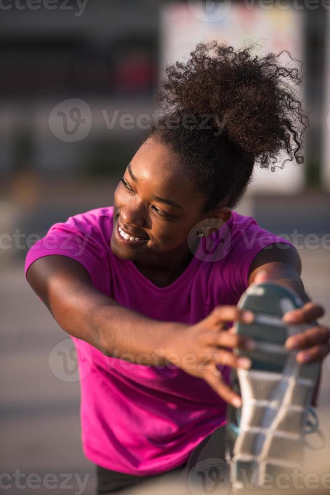 afrikansk amerikan kvinna håller på med uppvärmningen upp och stretching foto