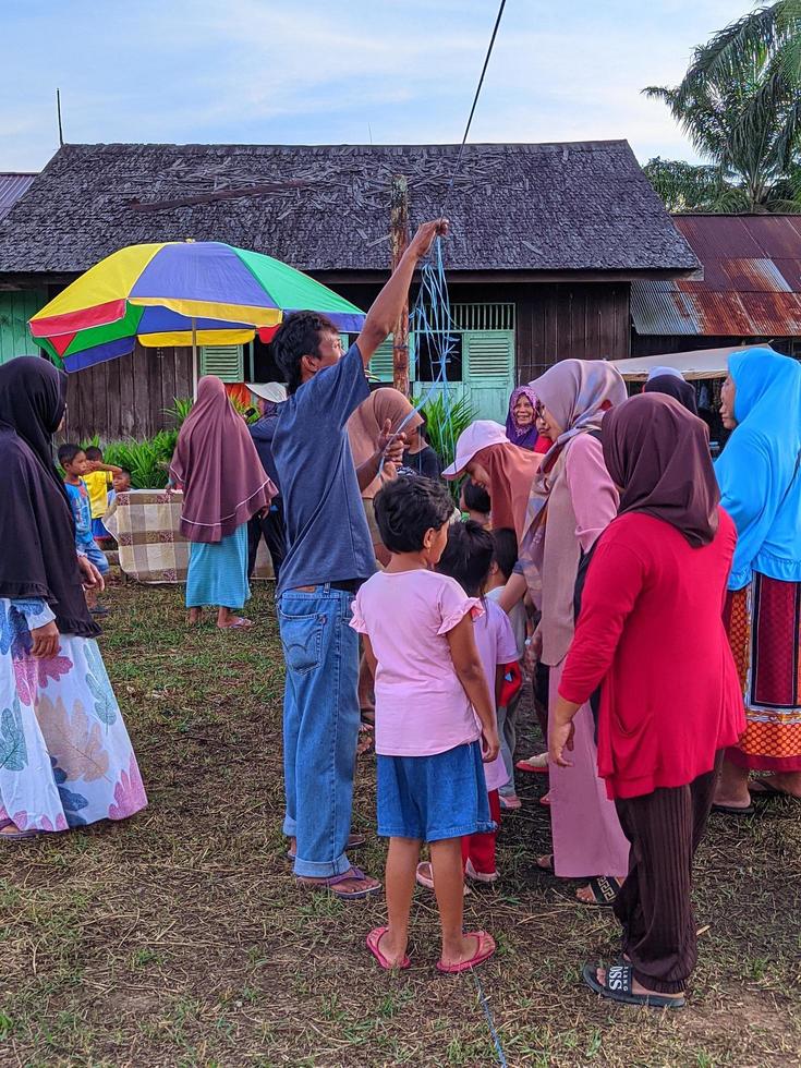 de spänning av vuxna och barn tar del i en kracker äter konkurrens till liva upp de oberoende dag av de republik av Indonesien, öst kalimantan, indonesien augusti 13, 2022 foto