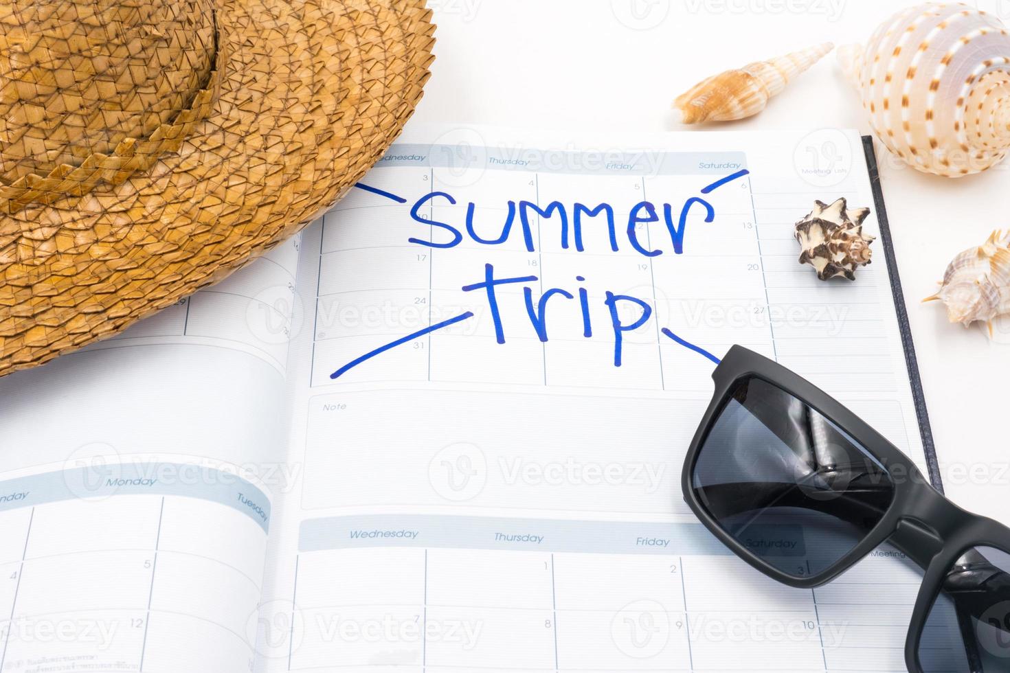 hatt med solglasögon, kalender och snäckskal på vit bakgrund, sommar Semester begrepp foto