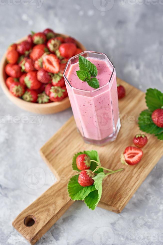 jordgubb mjölk skaka i en glas burk och färsk jordgubbar med löv foto