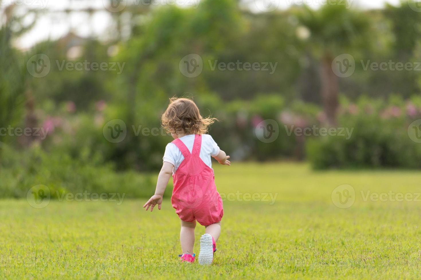 liten flicka utgifterna tid på bakgård foto