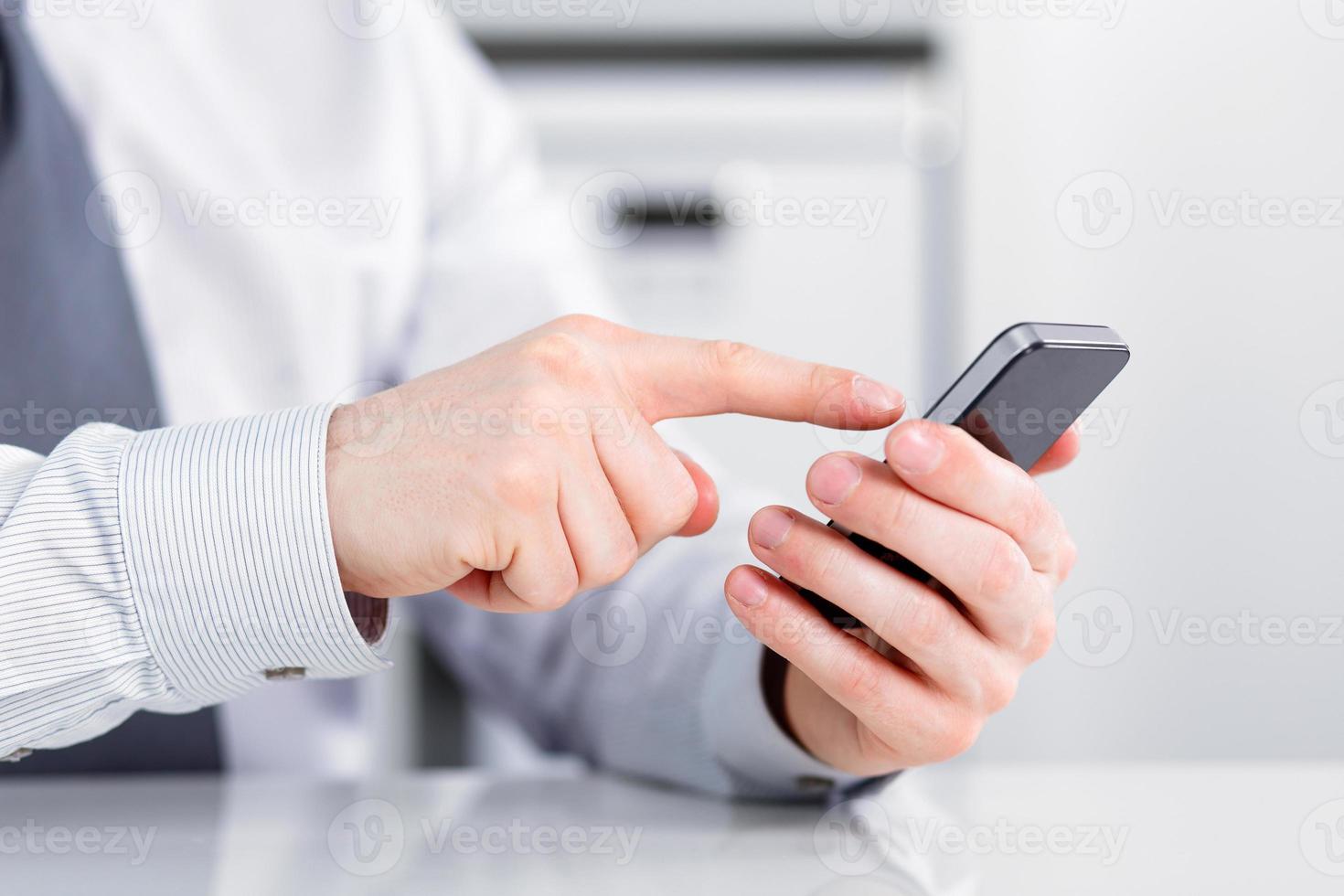 manlig hand som håller en mobiltelefon och skriver foto