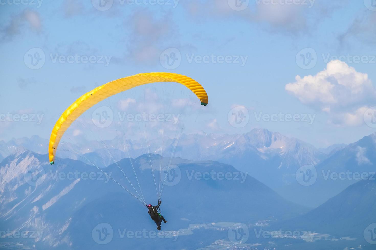 paraglider stigande i de blå himmel över de skön berg. foto