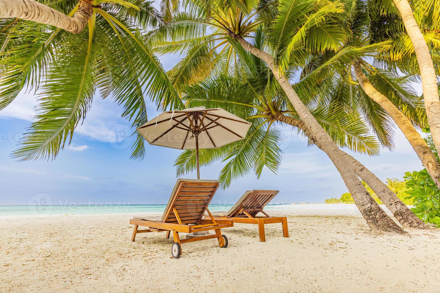 fantastisk romantisk strand. stolar på sandstranden nära havet. sommar semester semester koncept för turism. tropiskt ölandskap. lugnt strandlandskap, koppla av vid havets horisont, palmblad foto