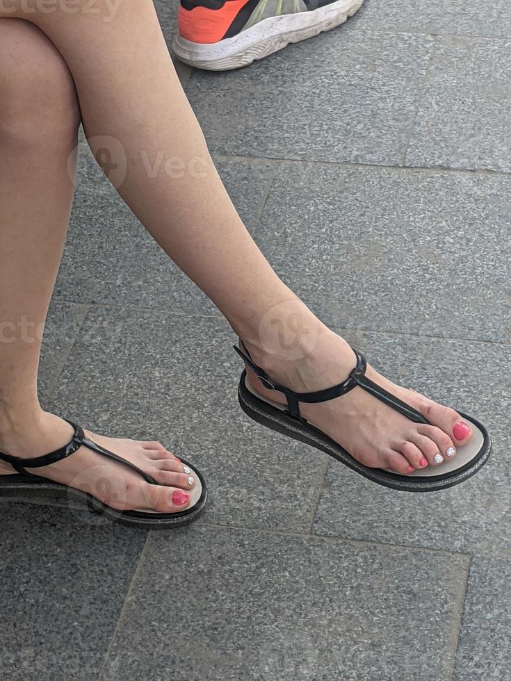 kvinna ben i sandaler. sommar gata mode. foto