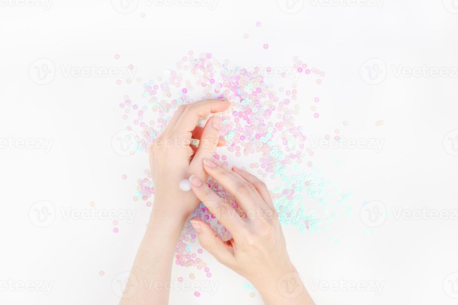 kvinna händer med grädde på vit pärla bakgrund foto