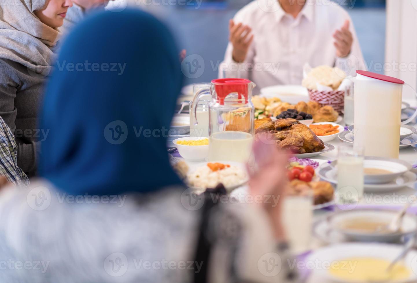 modern multietnisk muslim familj bön- innan har iftar middag foto