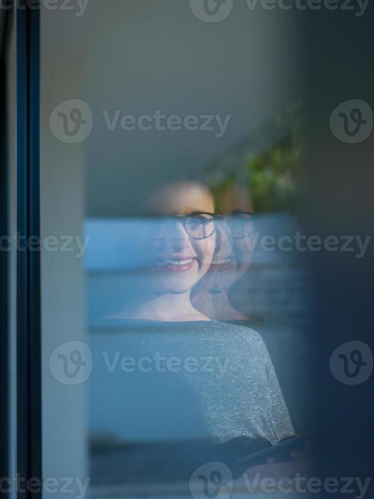 kvinna använder sig av läsplatta på Hem förbi de fönster foto