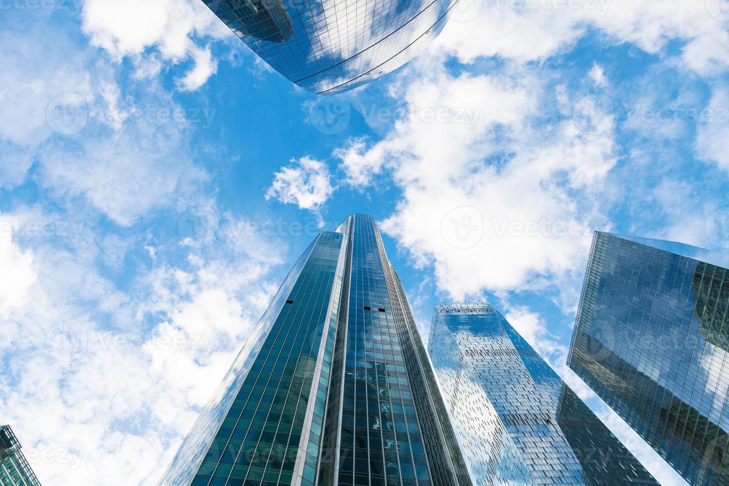 blå himmel med moln och blast av glas skyskrapor foto