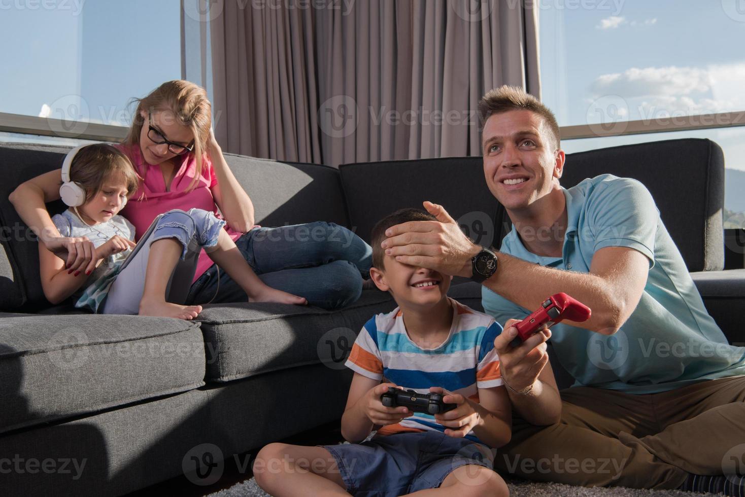 Lycklig familj spelar en video spel foto