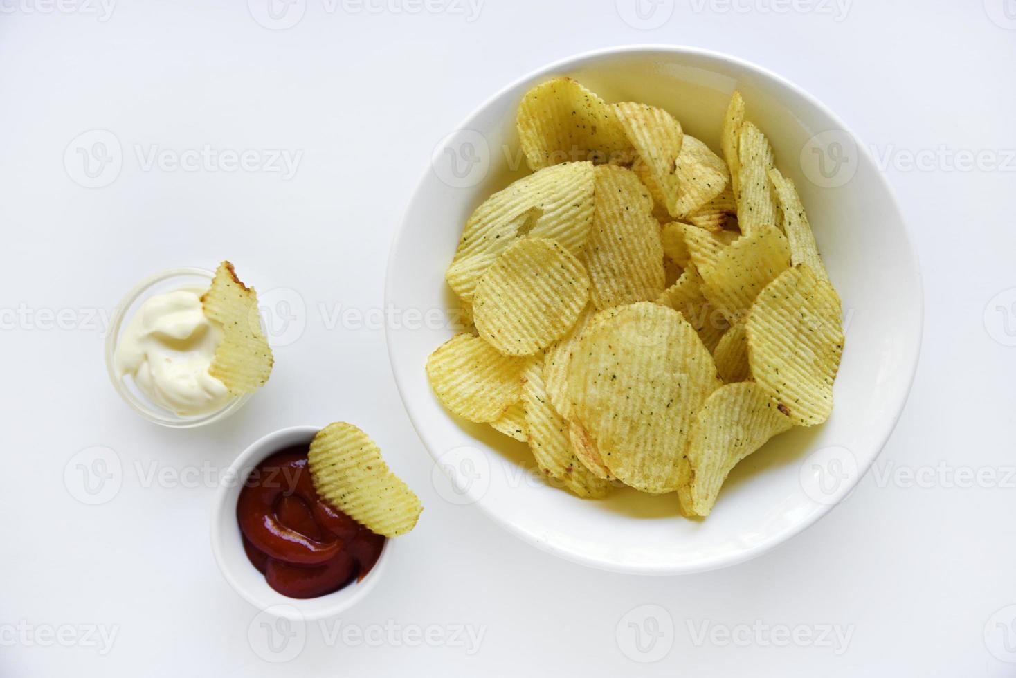 korrugerad potatis pommes frites med peppar på en vit bakgrund. utsökt snabb mat pommes frites. med sås. foto