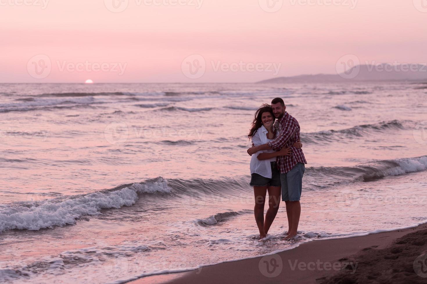 Lycklig romantisk mitten åldrig par njuter skön solnedgång promenad på de strand. resa semester pensionering livsstil begrepp foto