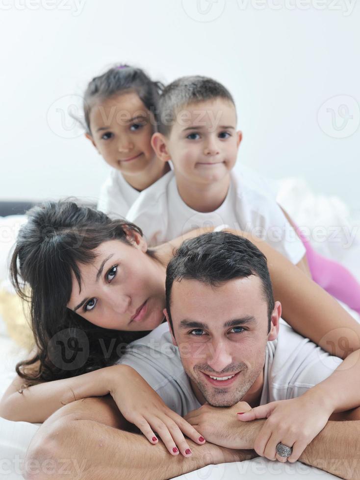 Lycklig ung familj i deras sovrum foto
