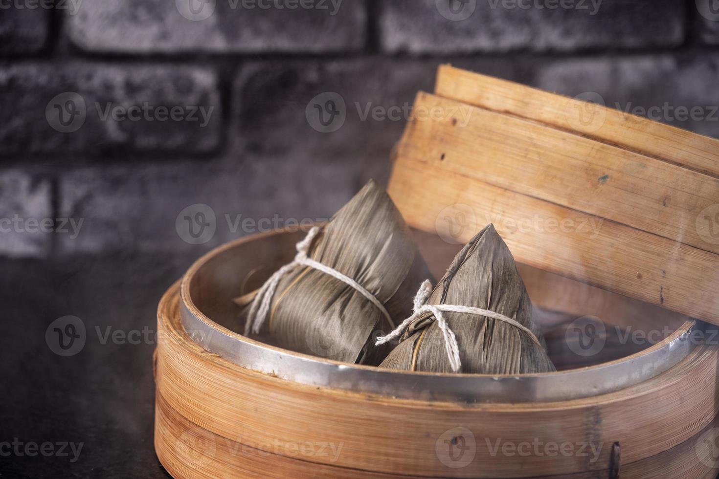 ris dumpling, zongzi - kinesisk ris dumpling zongzi på svart tegel bakgrund skiffer bord, begreppet drakbåt festival traditionell mat, närbild. foto