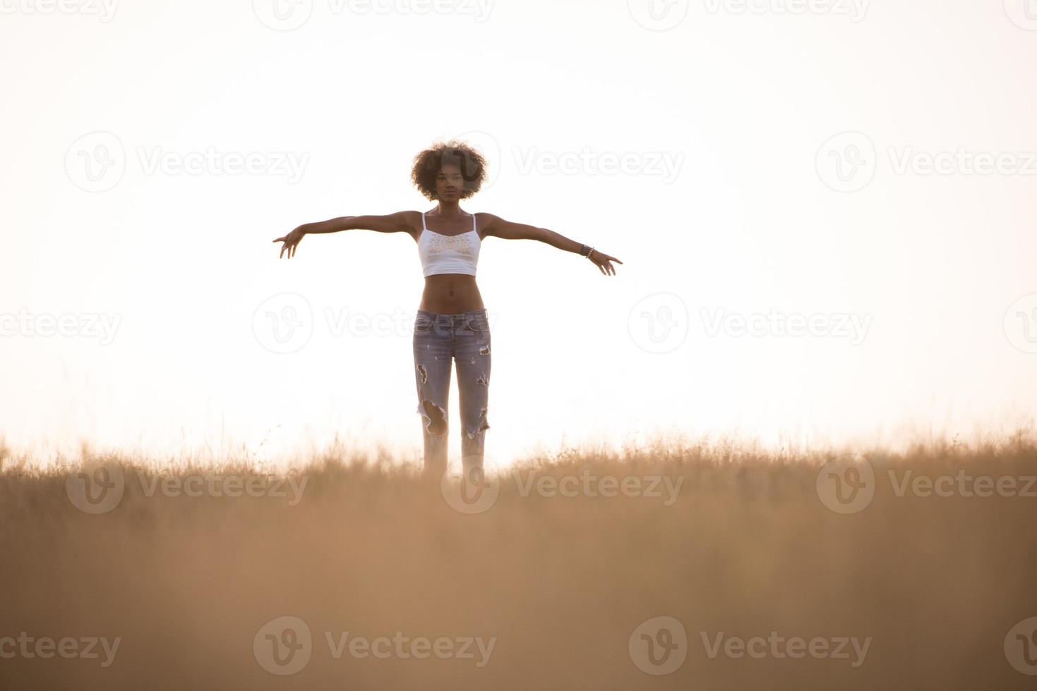 ung svart flicka danser utomhus i en äng foto