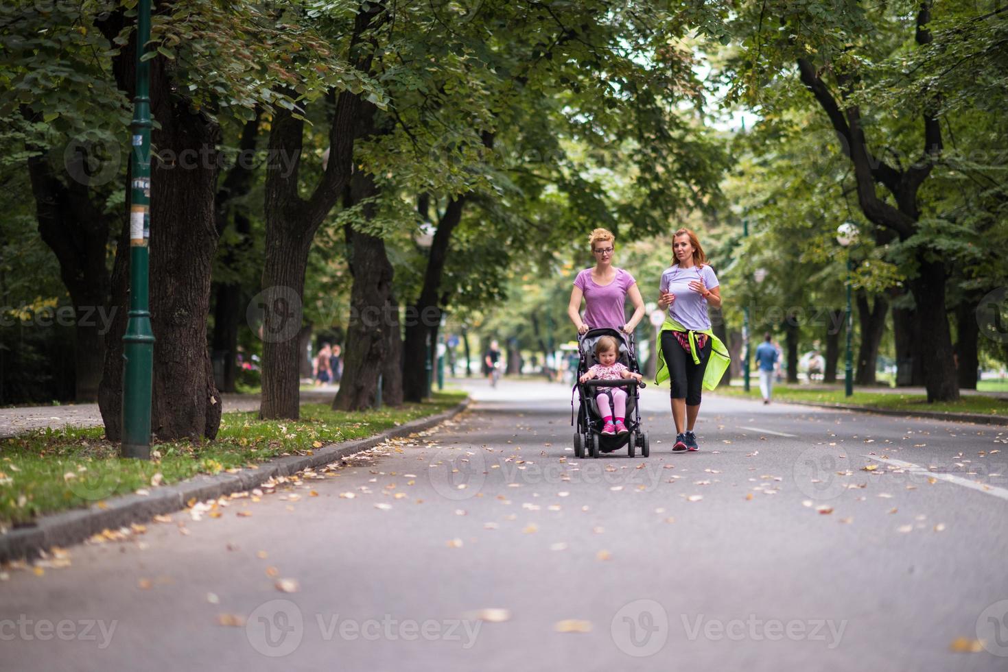 kvinnor med bebis sittvagn joggning tillsammans foto