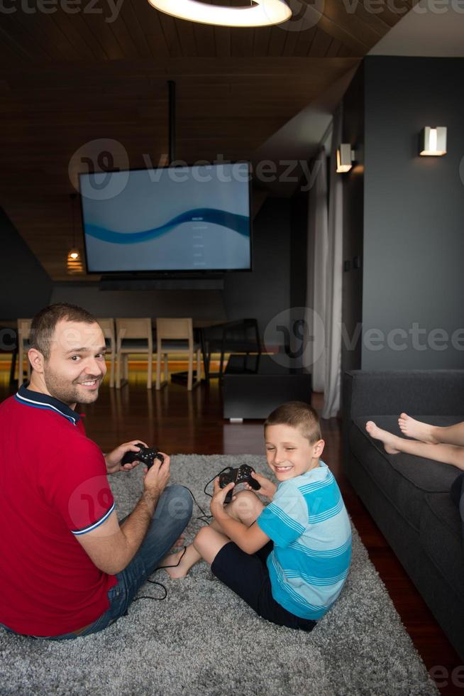 Lycklig familj spelar en video spel foto