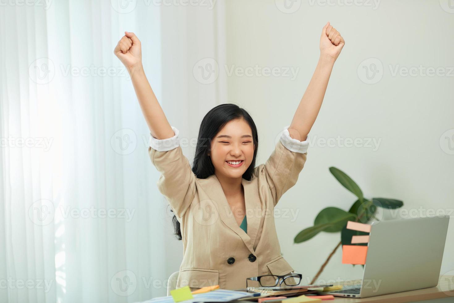 ung flicka studerande vinnare fira seger triumf sitta på Hem skrivbord foto
