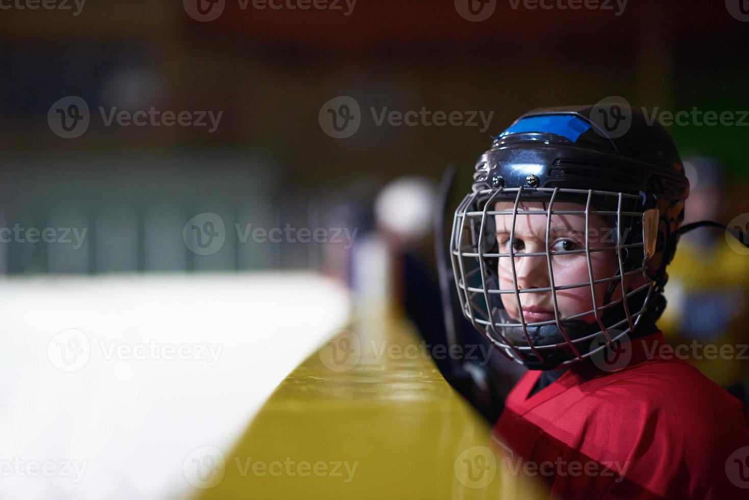 barn is hockey spelare på bänk foto