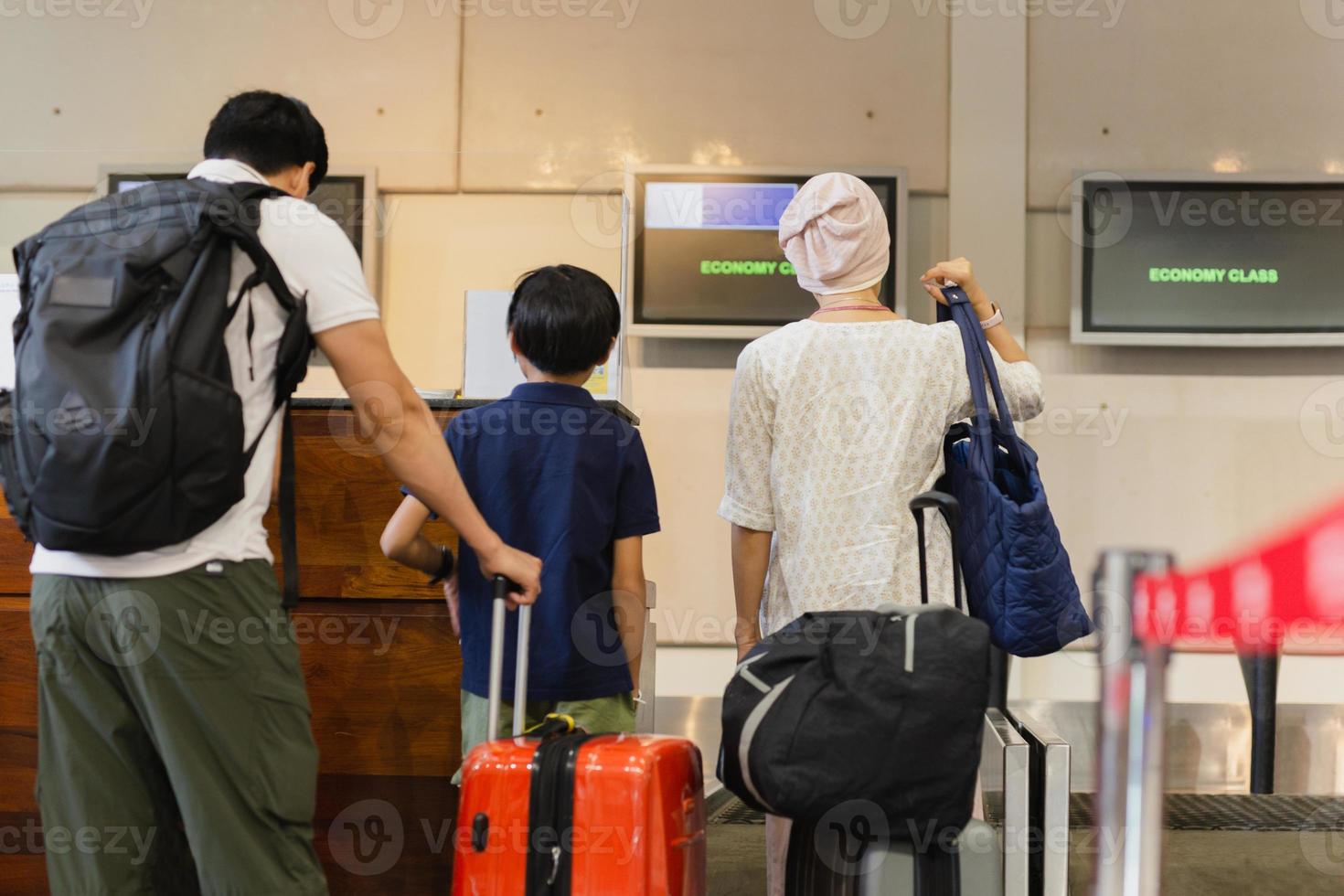 familj stående med bagage kolla upp i på flygplats. foto