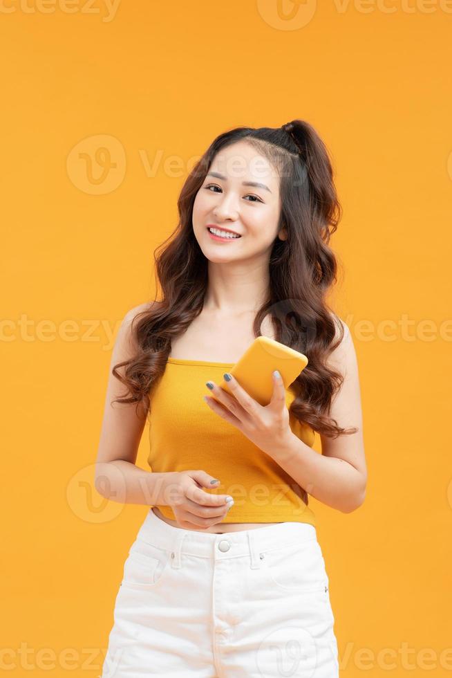 ung kvinna över isolerat gul bakgrund sändning en meddelande med de mobil foto