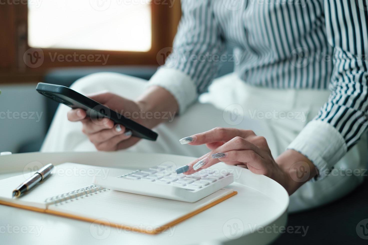 företag kvinna hand innehav penna ser på Bank besparingar konto Ansökan på cell telefon. konto eller sparande pengar eller försäkring begrepp. foto