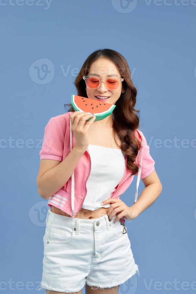 porträtt Lycklig kvinna är innehav skiva av vattenmelon över färgrik blå bakgrund foto