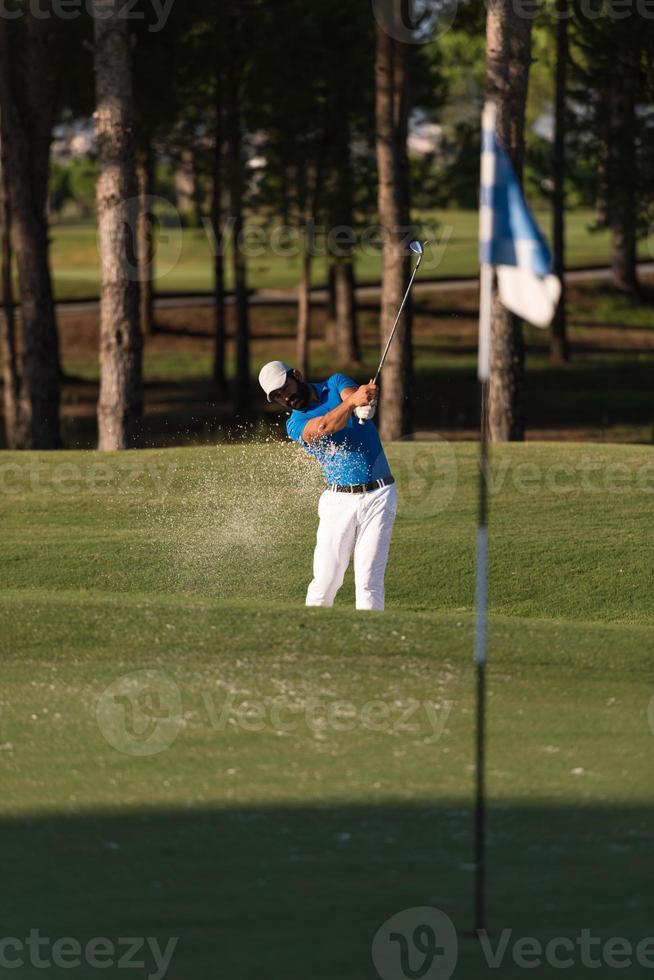 proffs golfspelare slå en sand bunkra skott foto