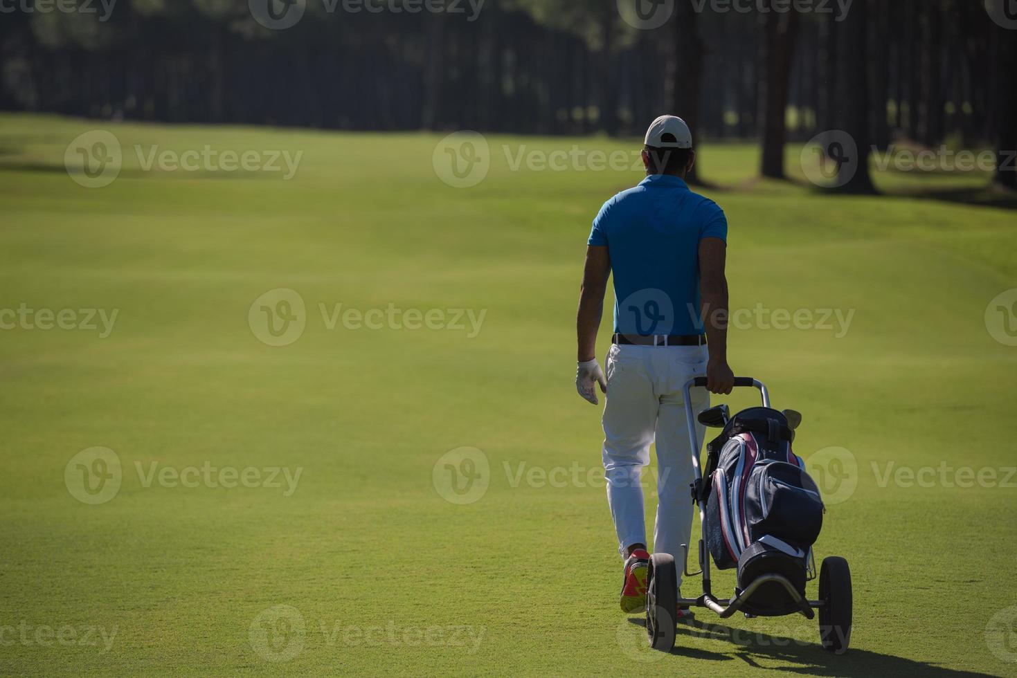 golf spelare gående med hjul väska foto