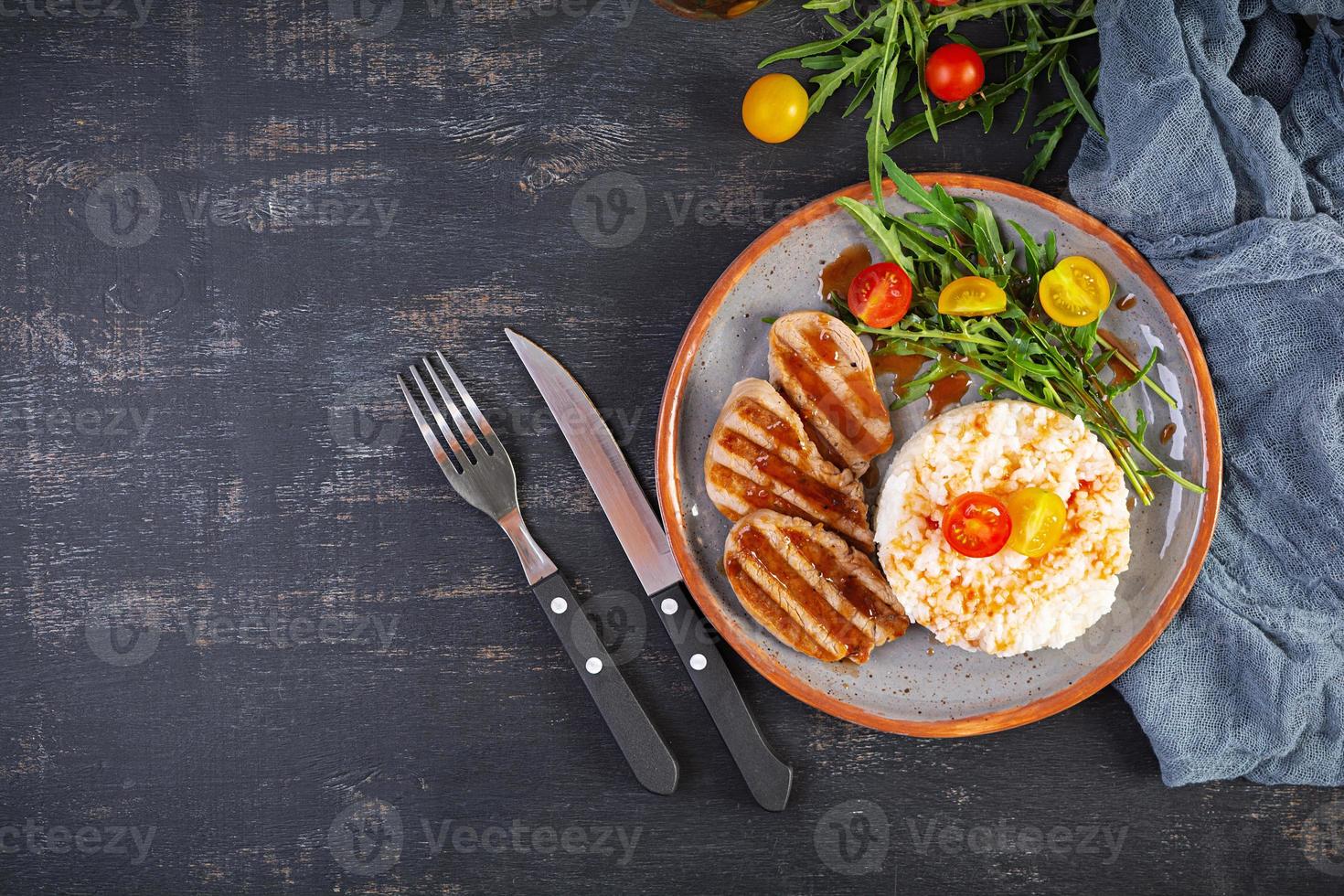 ris med grillad fläsk kött, tomater och grön örter. topp se foto