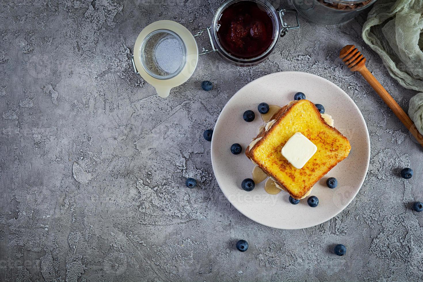 franska rostat bröd med banan, blåbär, honung och jordgubb sylt. utsökt morgon- frukost eller brunch med rostat bröd och småkakor. topp se foto
