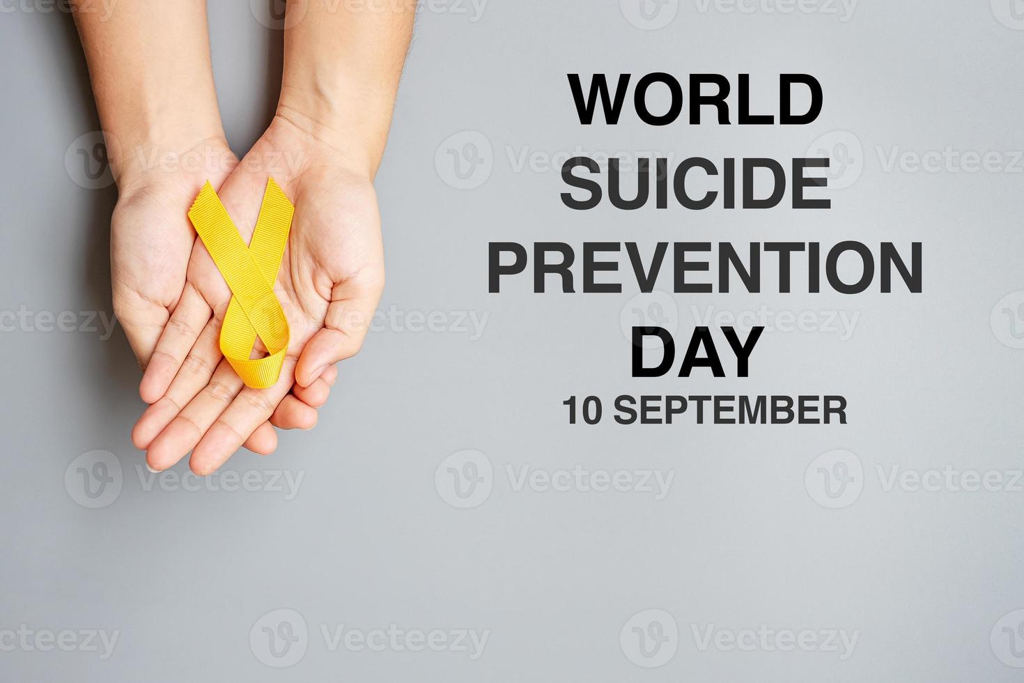 värld självmord förebyggande dag, hand innehav gul band för stödjande människor levande och sjukdom foto