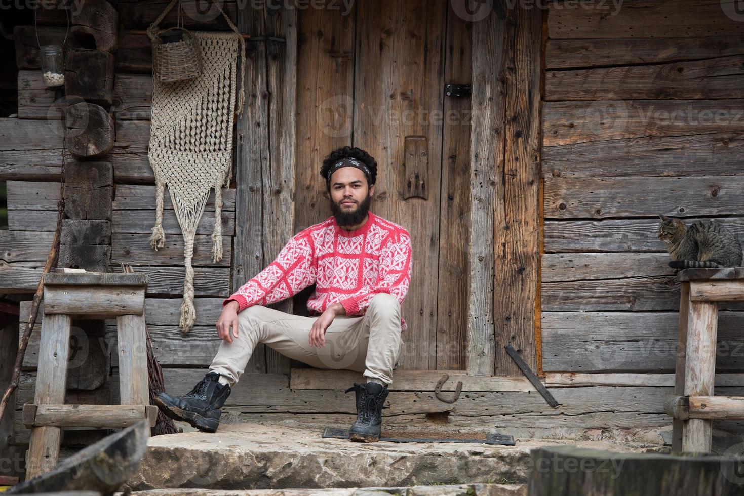 porträtt av ung hipster i främre av trä- hus foto
