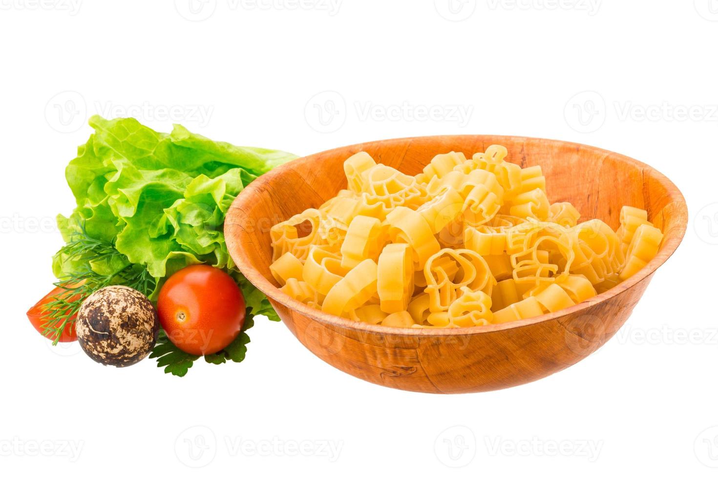 rå pasta i en skål på vit bakgrund foto