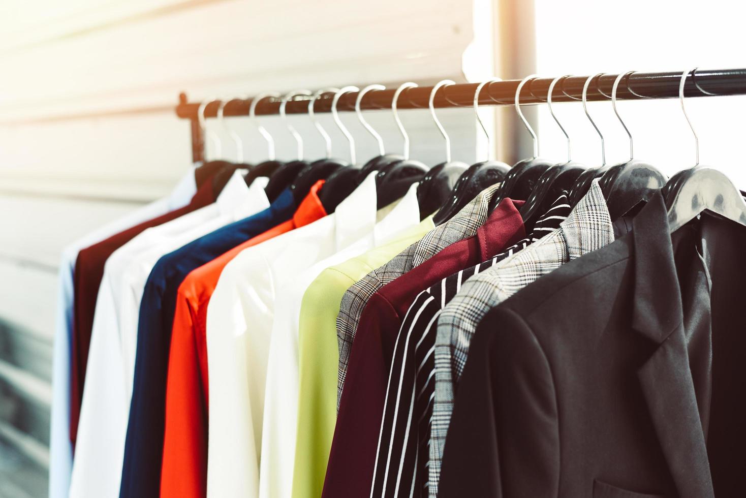 män mode kläder - hängande kläder kostym färgrik eller garderob kuggstång annorlunda färgad man kostymer i en garderob på galgar i en Lagra eller utställningslokal foto