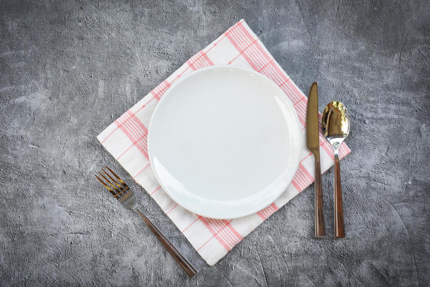 plats miljö tabell mat med uppsättning av vit tallrik på tabell torkdukar eller servett på de middag tömma tallrik sked gaffel och kniv på tabell foto