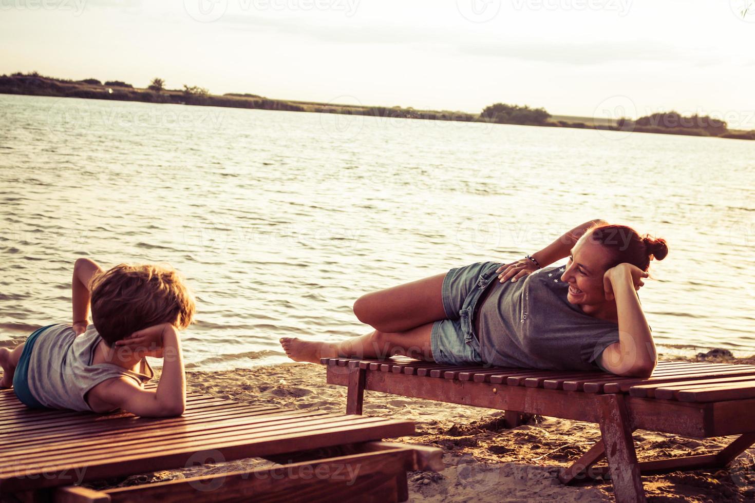 Lycklig mor och son har roligt på de strand i sommar dag. foto