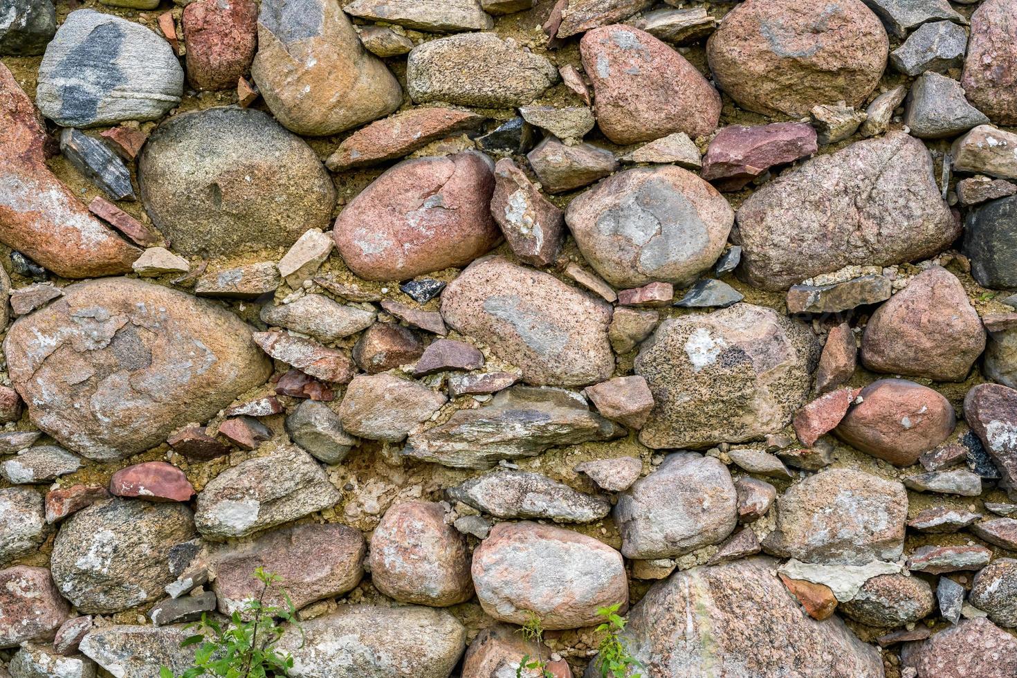 yta av gammal vägg av enorm stenar av en förstörd gammal byggnad foto