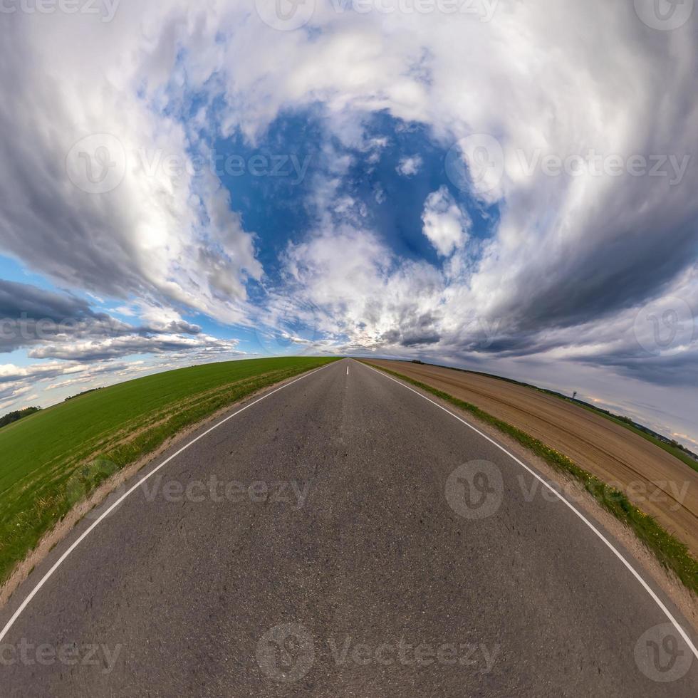 hemisfär av de planet på ett asfalt väg stretching bortom de horisont med blå himmel och skön moln. sfärisk abstrakt antenn se. krökning av Plats. foto