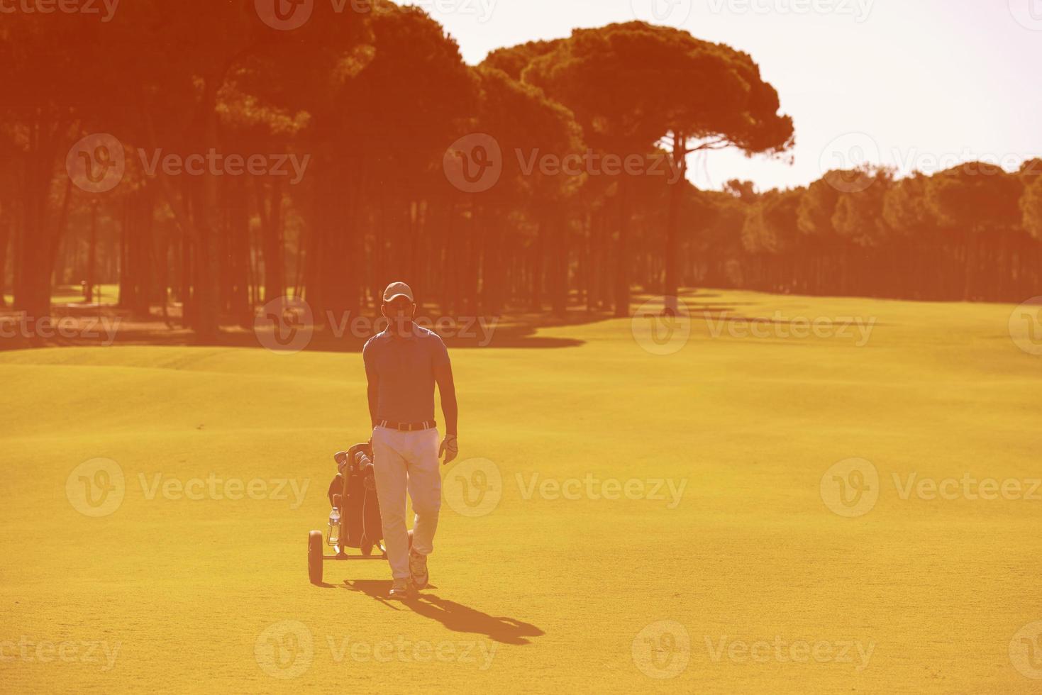 golf spelare gående med hjul väska foto