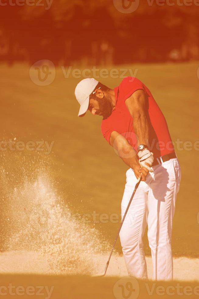 golfspelare slå en sand bunkra skott foto