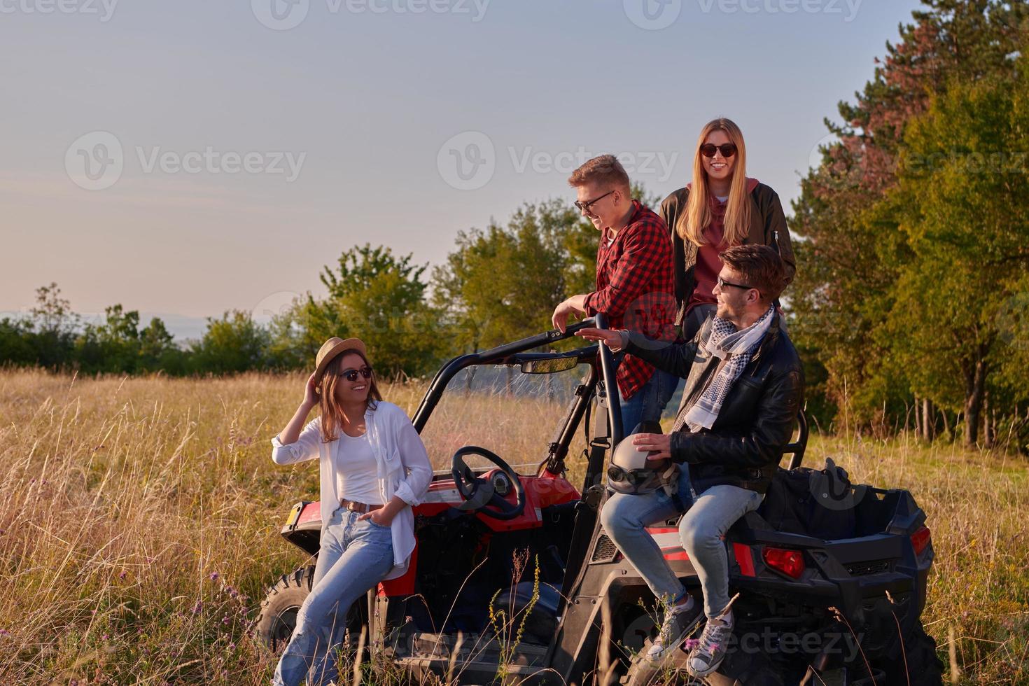 grupp ung Lycklig människor njuter skön solig dag medan körning en av väg buggy bil foto