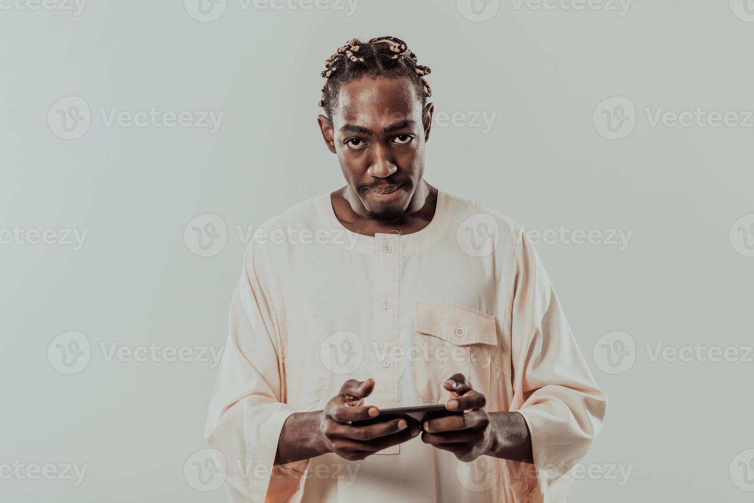 afrikansk man använder sig av smartphone och bär traditionell sudan kläder. foto