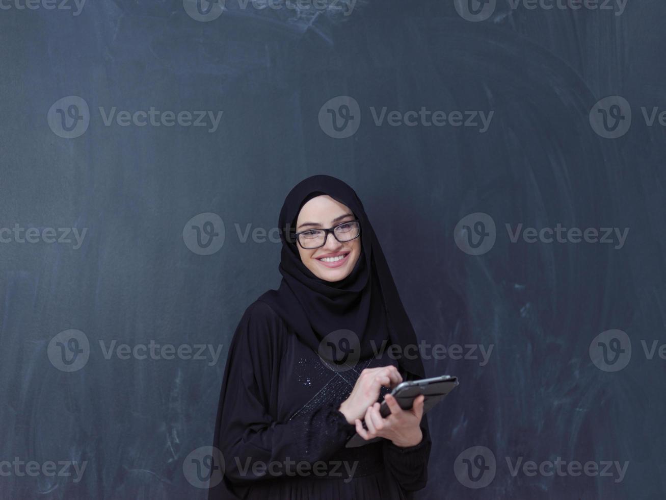 ung muslim företag kvinna använder sig av läsplatta dator foto