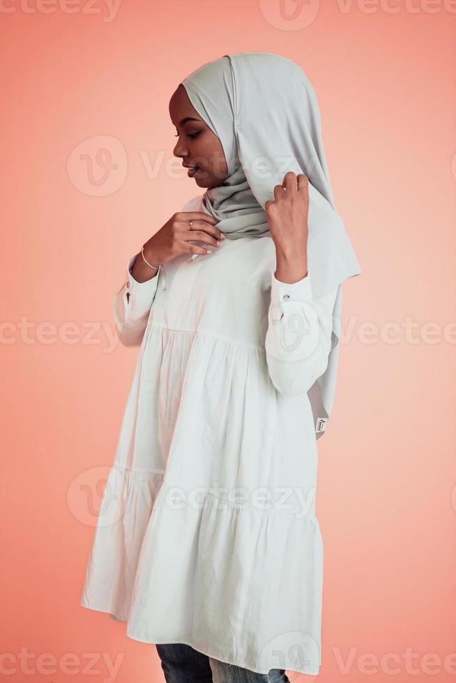 porträtt av ung modern muslim afro skönhet bär traditionell islamic kläder på plast rosa bakgrund. selektiv fokus foto