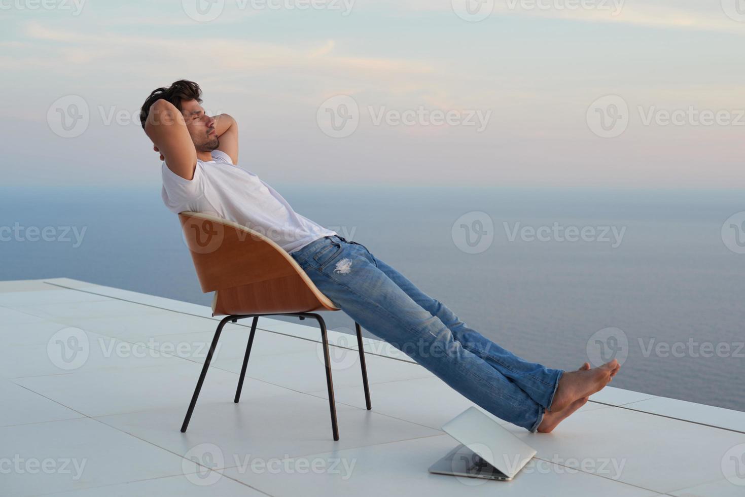avslappnad ung man på Hem på balkong foto
