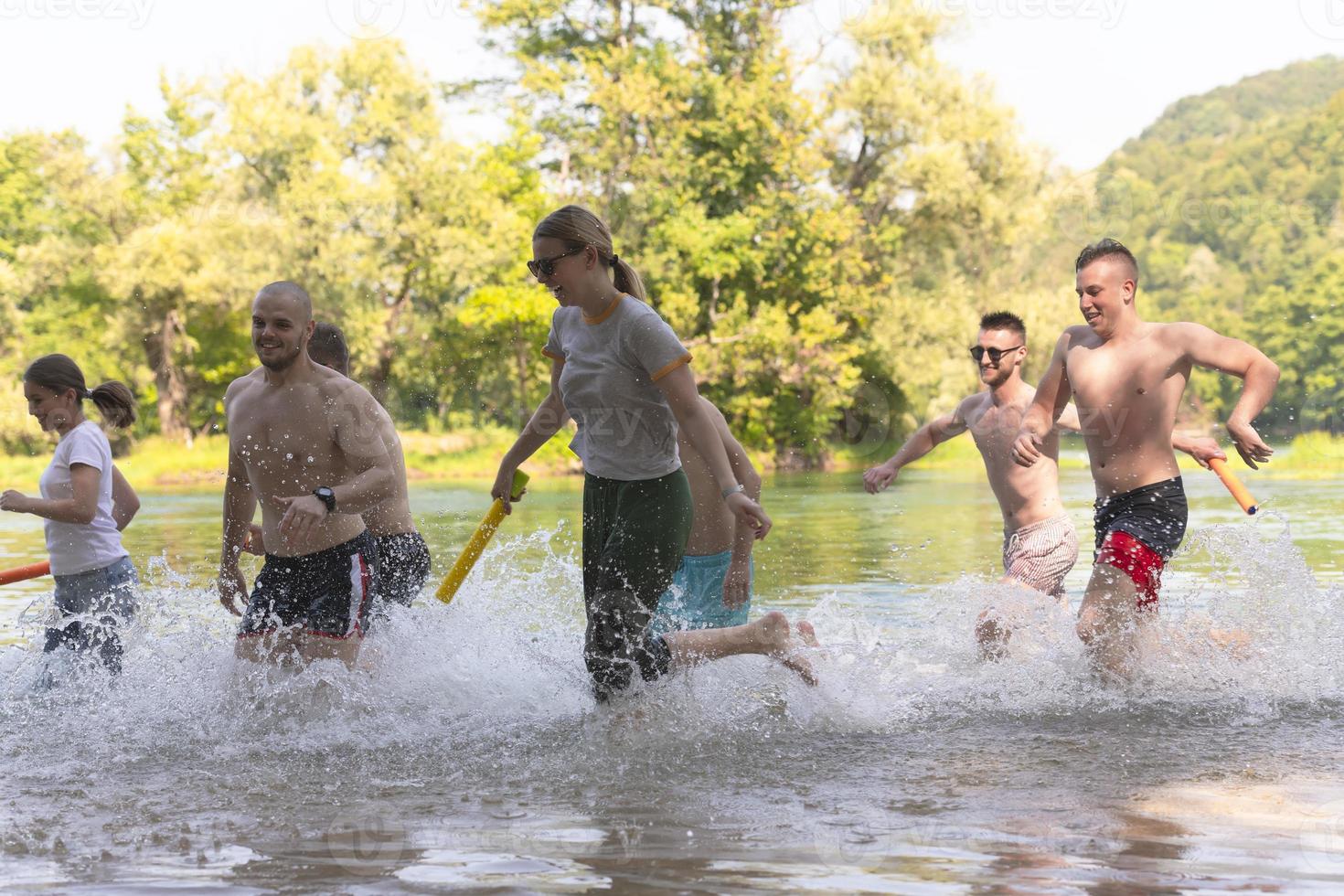 grupp av Lycklig vänner har roligt på flod foto