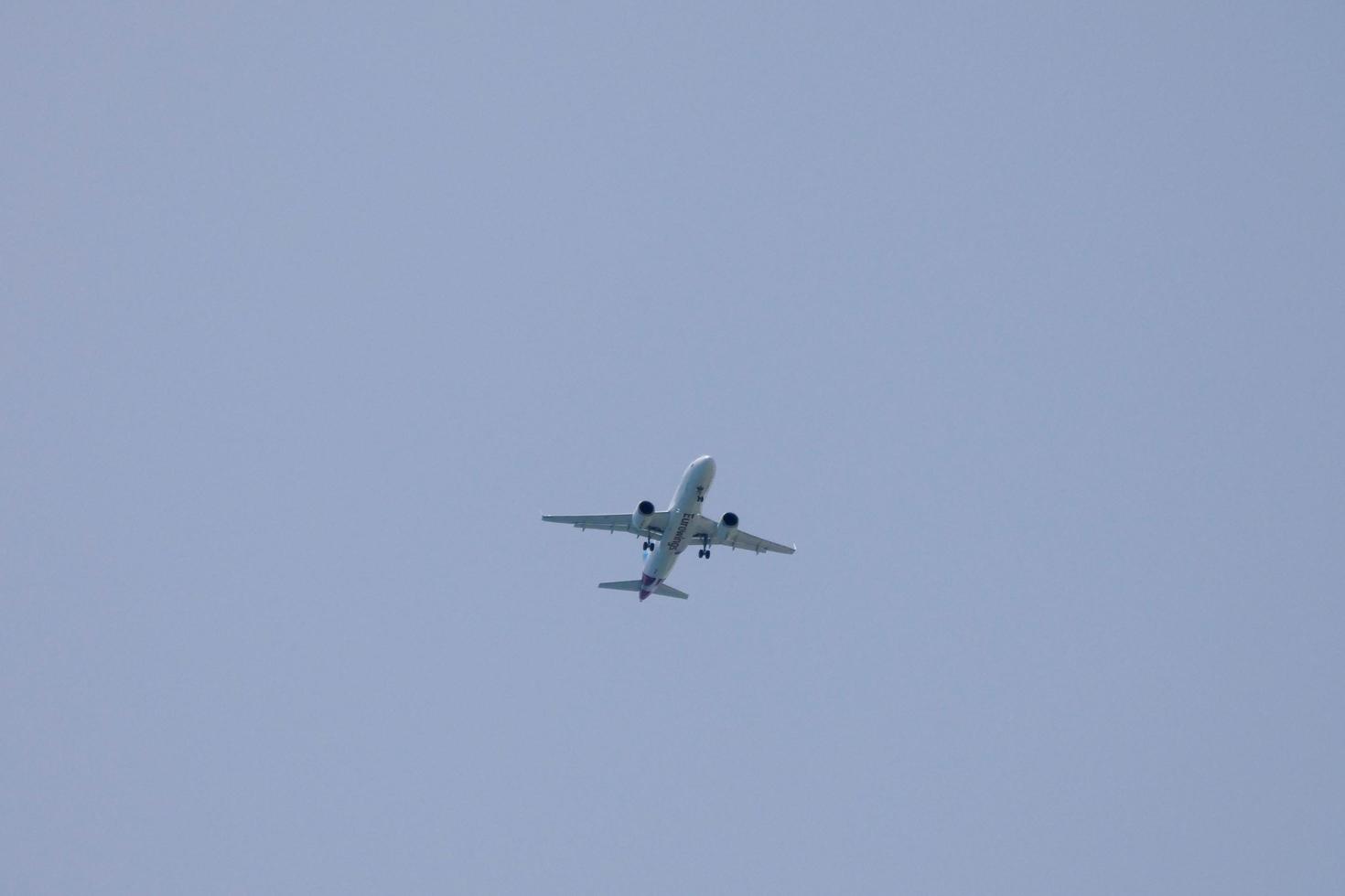 kommersiell flygplan flygande under blå himmel och anländer på de flygplats foto